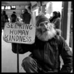 homeless man with a sign says seeking human kindness