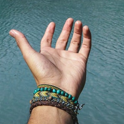 hand reaching out over ocean